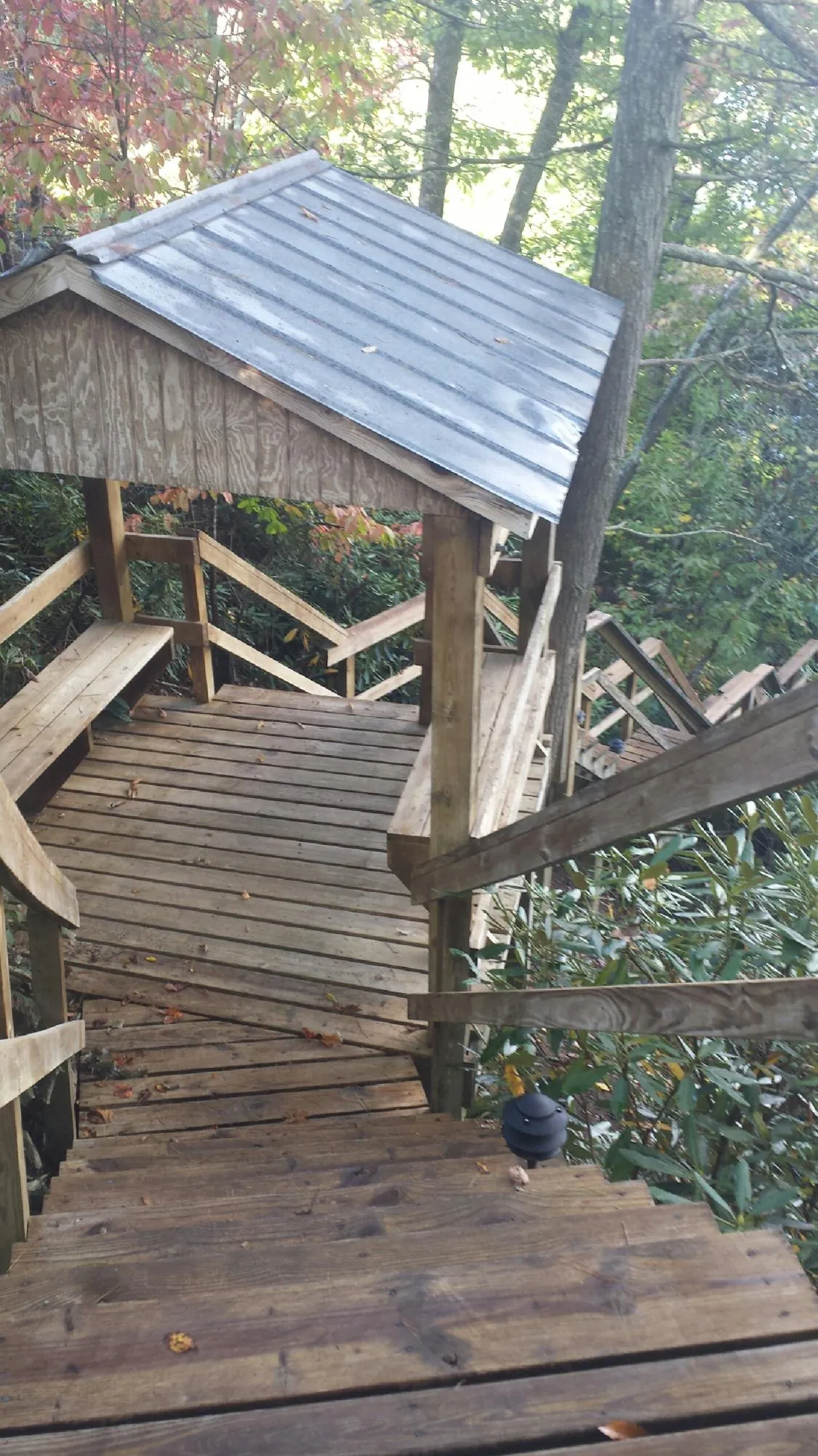 Metal roofed shelter over wooden steps on a wooded walkway — Skylight Repair & Installation work by our crew in Lindon