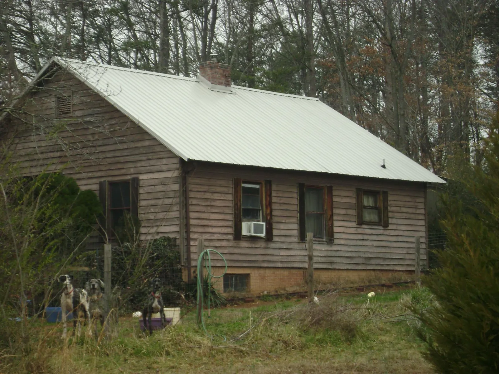 White metal roof on an old wood sided farmhouse, from a Metal Roof Installation job in Lindon